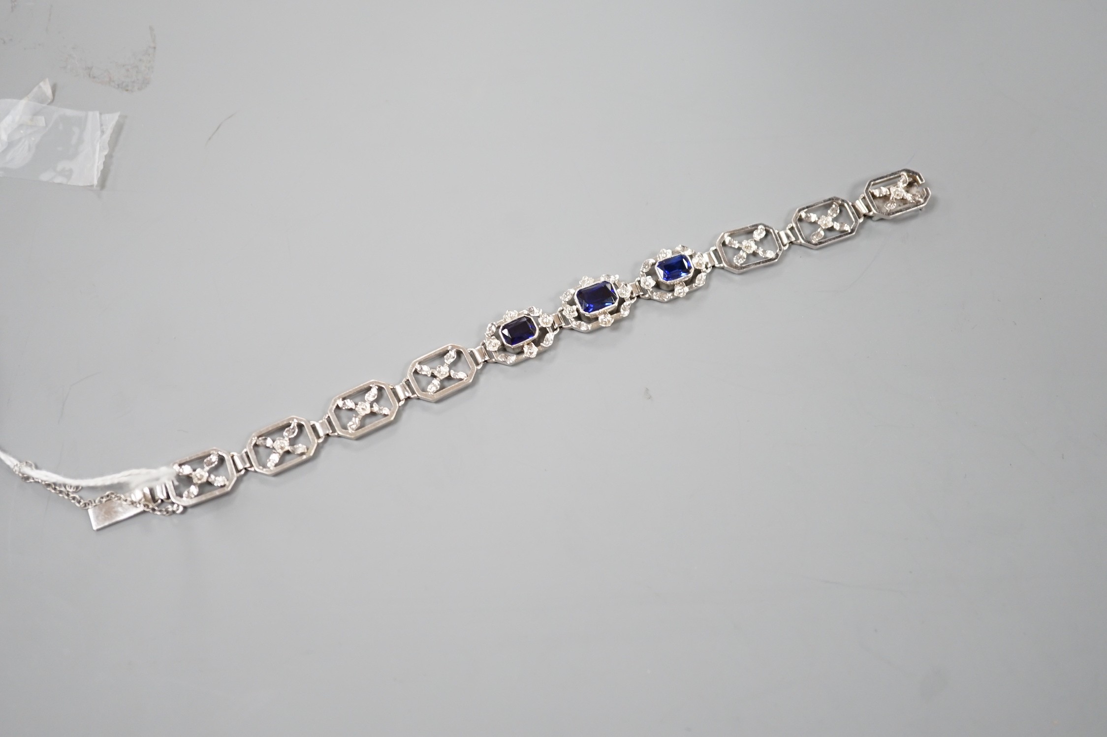 A modern 9ct white metal and three stone emerald cut sapphire set pierced link bracelet, approx. 18cm, gross weight 16.7 grams.